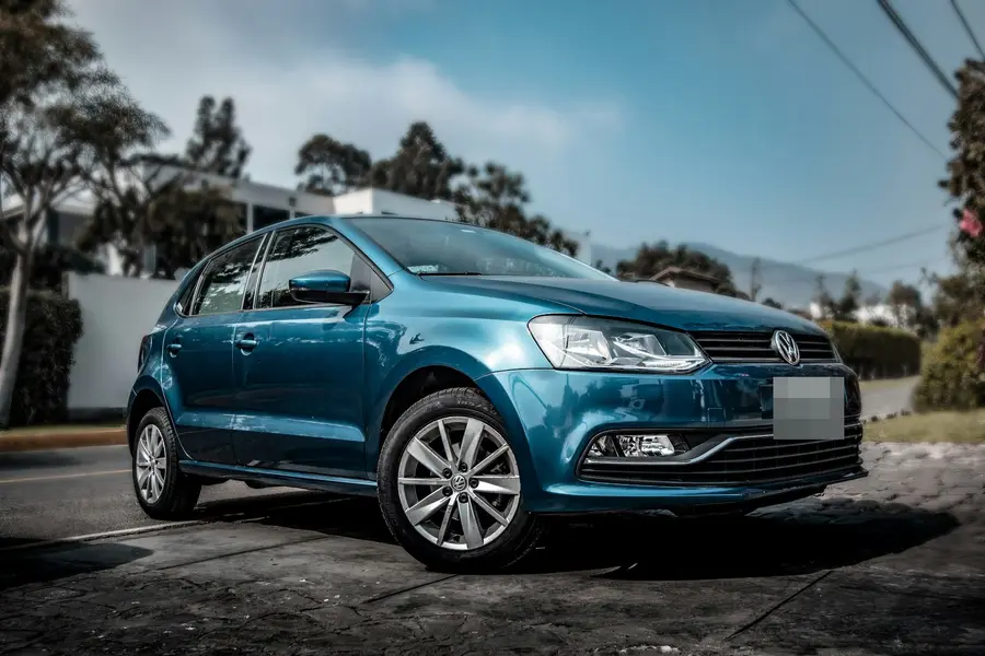 A blue hatchback parked on a quiet street