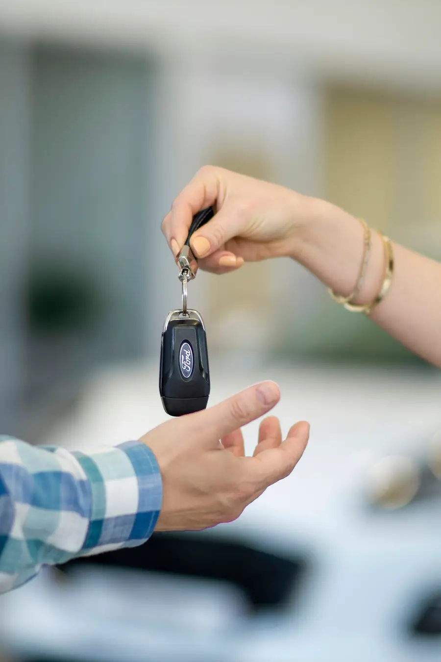 One person handing a car key to another