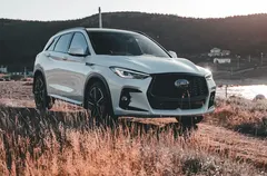 A white compact SUV parked in golden grass