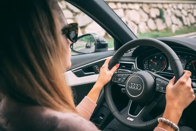 A woman driving, hands on the steering wheel